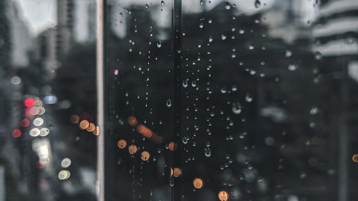 Raindrops on glass with blurred city lights
