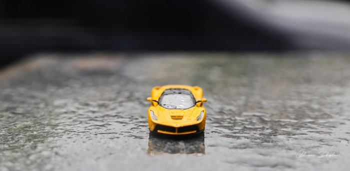 Yellow Ferrari LaFerrari toy car on wet surface