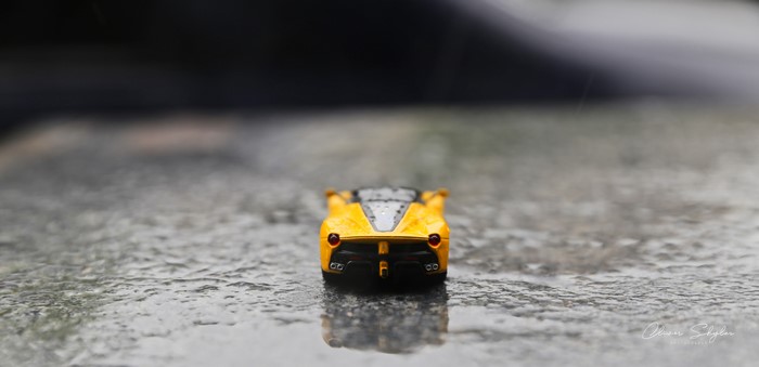 Yellow Ferrari LaFerrari toy car on wet surface