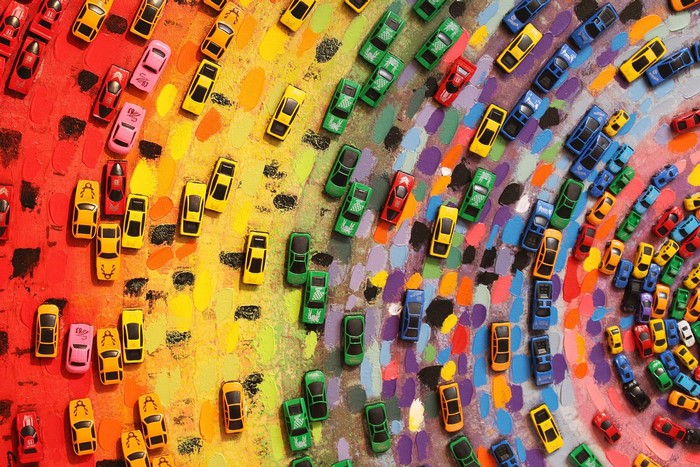 Colorful toy cars arranged on a painted surface
