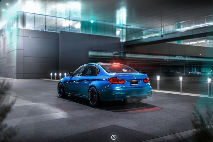 Blue BMW M3 Sedan parked outside modern building