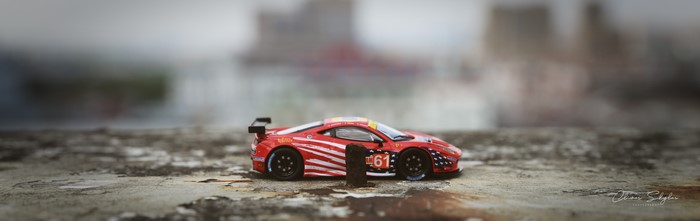 Red Ferrari 458 race car on textured surface