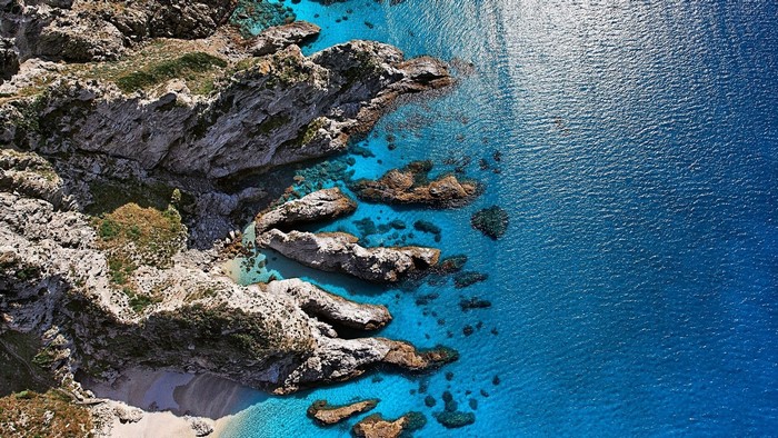 Aerial view of rocky cliffs and turquoise sea at Capo Vaticano, Italy