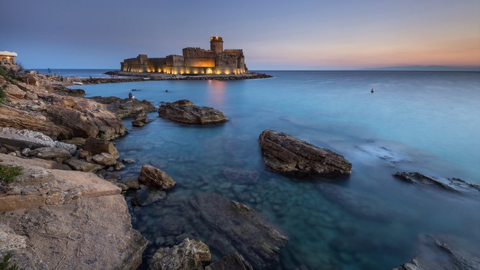 Castle on the sea at sunset in Le Castella, Italy