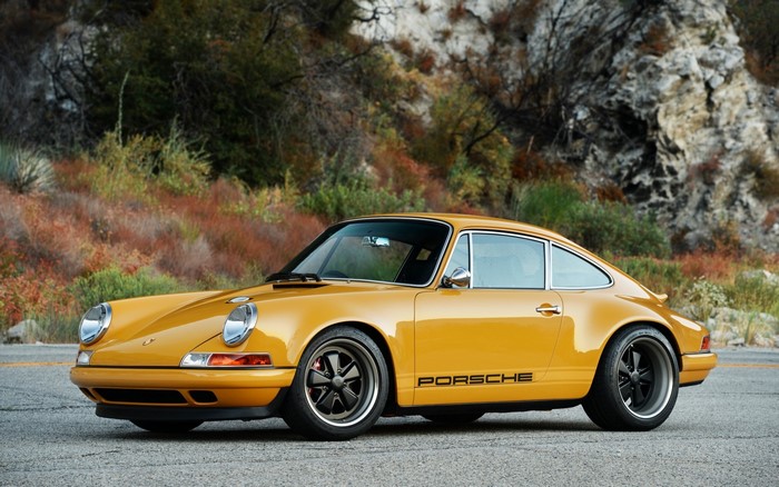 Yellow Porsche 911 parked on a road