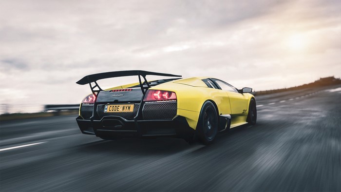Yellow Lamborghini Murcielago SV driving on road