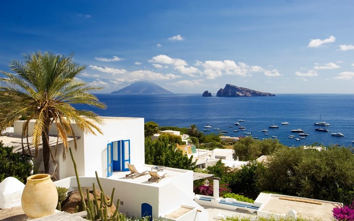 White villa overlooking the sea with boats and islands