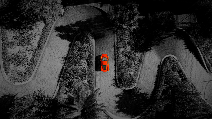 Orange Chevrolet Corvette C8 on a winding road