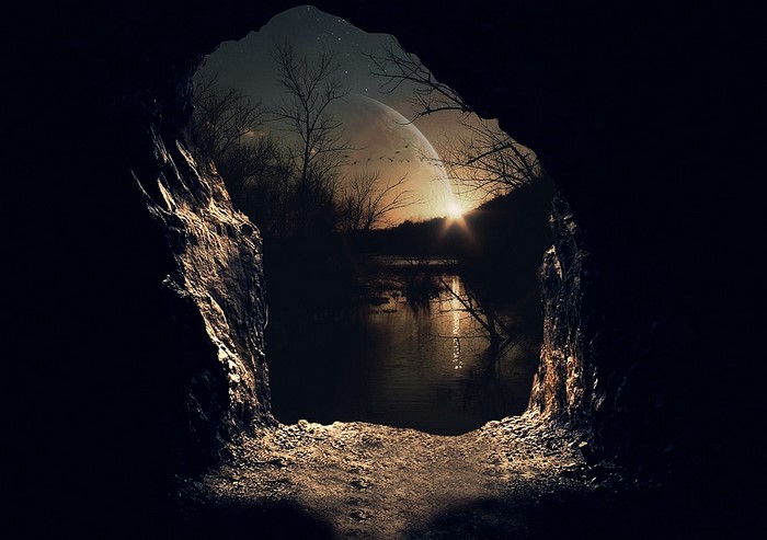 View from a cave to a lake with a large moon and stars