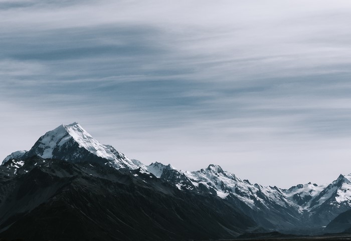 Snowy mountain peaks under a cloudy sky