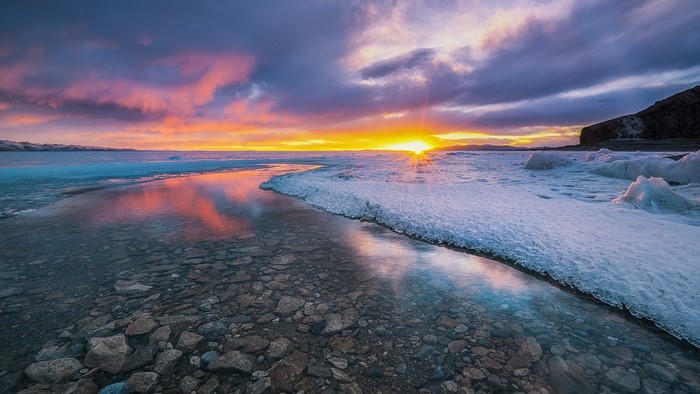 4K Sunrise over Icy Shoreline with Rocks
