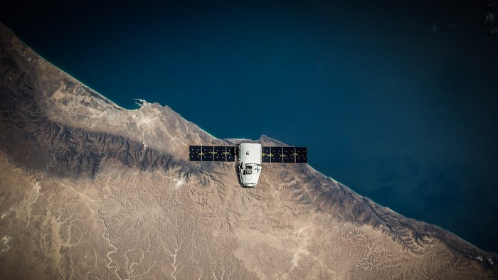 SpaceX Dragon spacecraft over Earth's coast