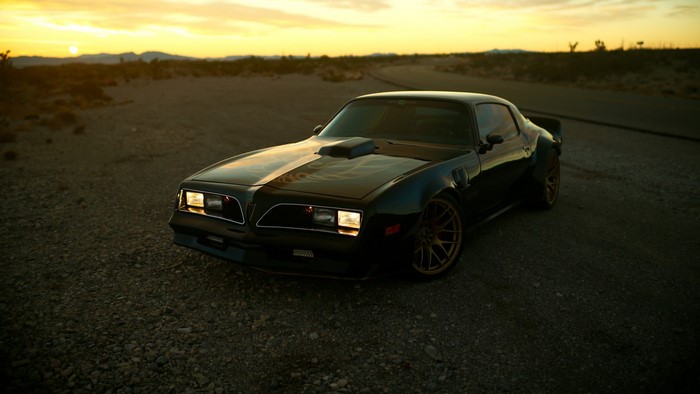 Pontiac Trans Am in a desert landscape at sunset