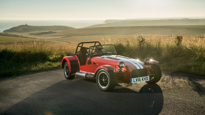 Red Caterham car on a coastal road