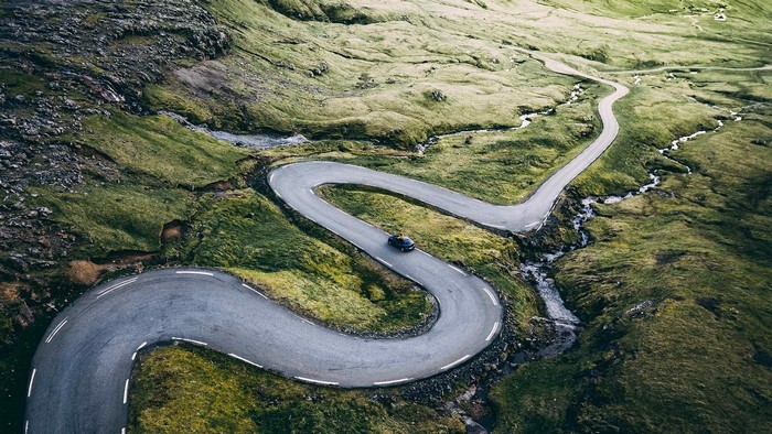 Car on a winding road in a green landscape