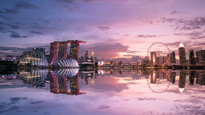Singapore cityscape with Marina Bay Sands and Singapore Flyer at sunset with reflection