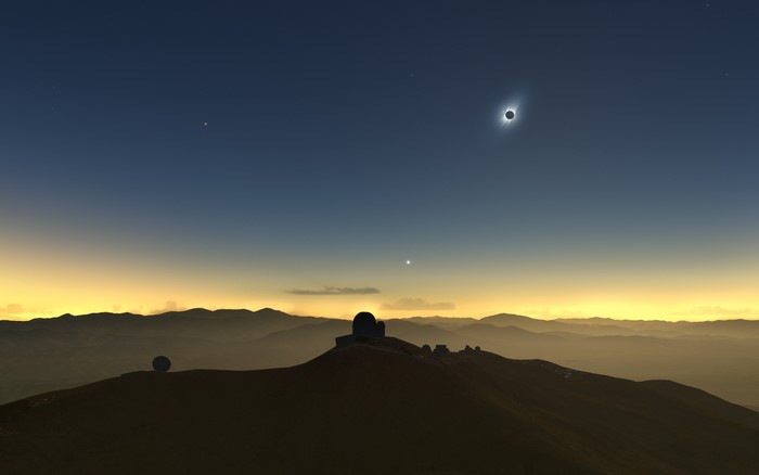 Solar eclipse over mountains with observatory