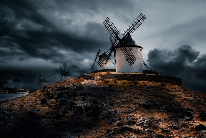 Windmills on a hill under a stormy sky