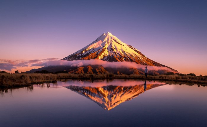 Mount Taranaki reflected in a lake at sunrise
