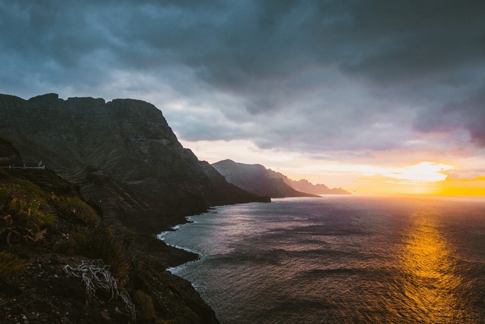Mountains and sea at sunset with dramatic clouds