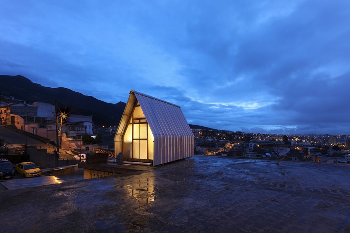 Modern A-frame house in a city at dusk