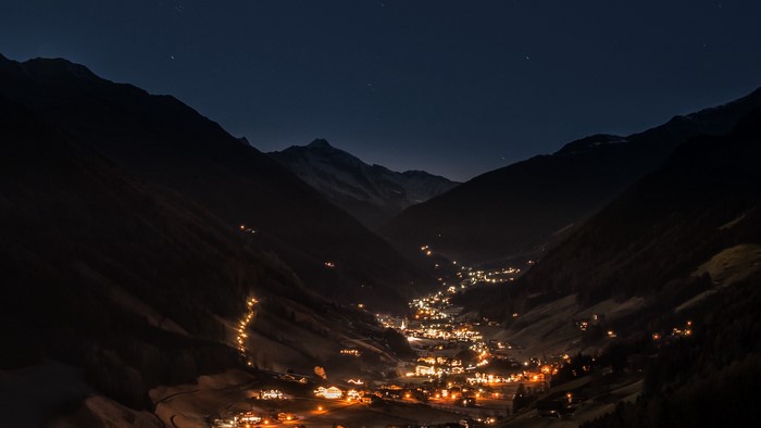 Mountain valley village at night with starry sky