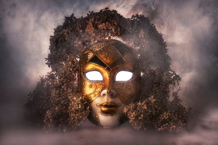 Golden Venetian mask with dried flowers and smoke