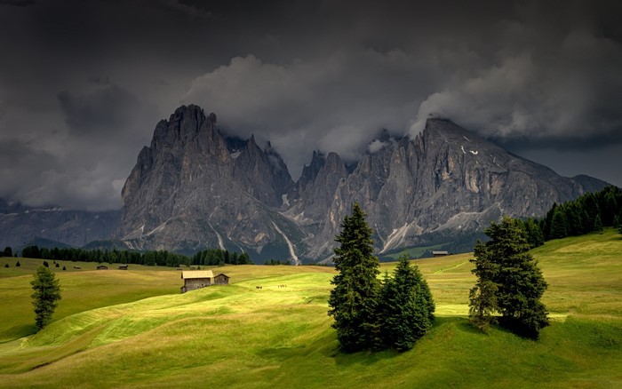 Alps mountains landscape with clouds and fields