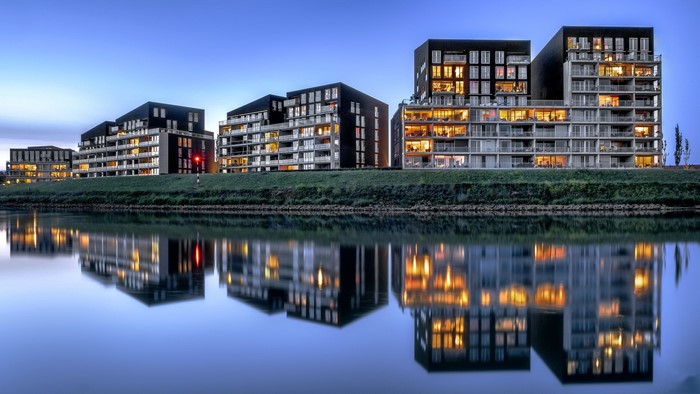 Modern buildings reflected in water at dusk in the Netherlands