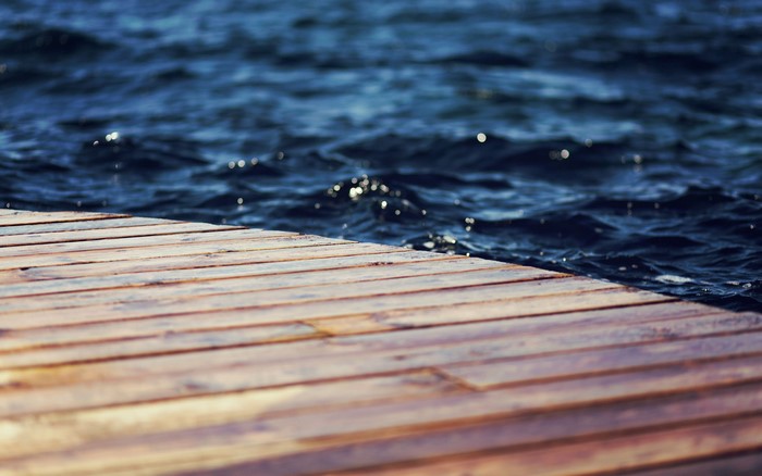Wooden pier by the dark blue water