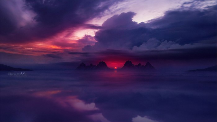 Mountains shrouded in mist during a vibrant sunset