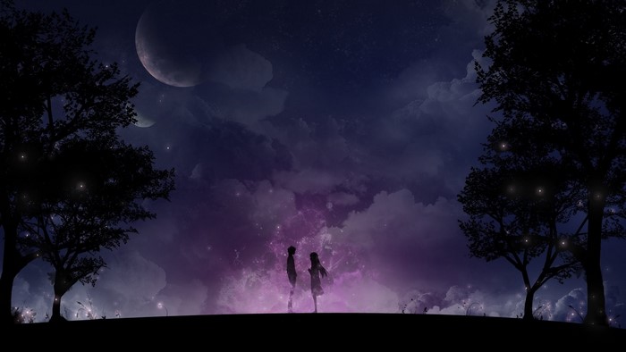 Couple silhouetted against a starry night sky with moons