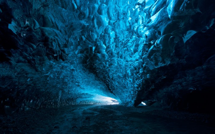 Blue ice cave with light shining through