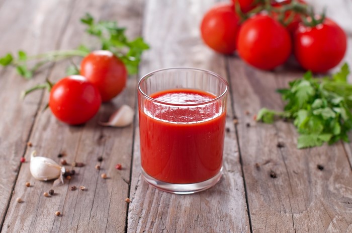 Glass of tomato juice with tomatoes, garlic, and spices