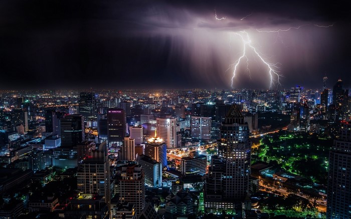 Lightning strikes over a city at night