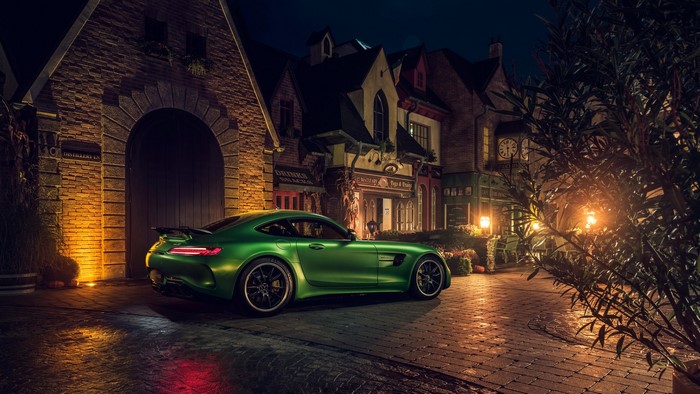 Green Mercedes-AMG GT R parked in a European town at night