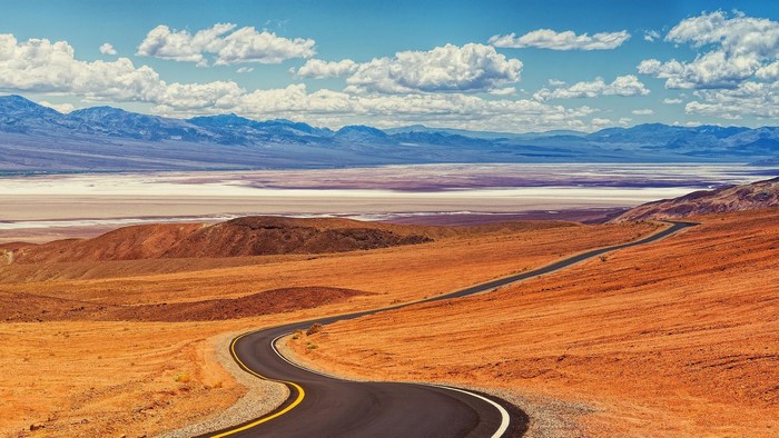 Winding road through Death Valley landscape with mountains