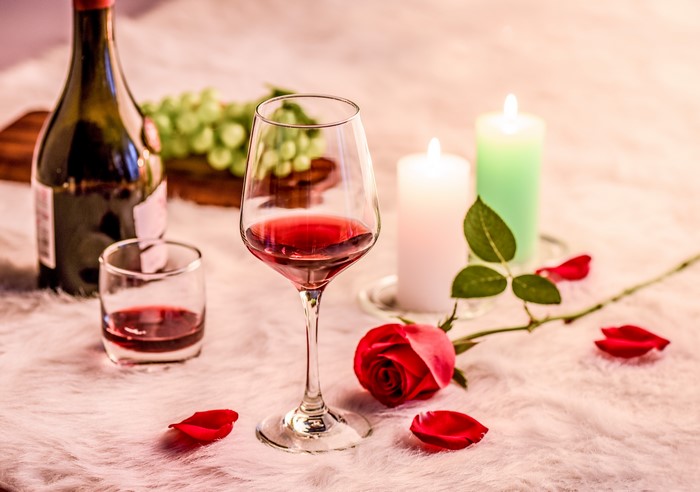 Red wine, candles, rose, and grapes