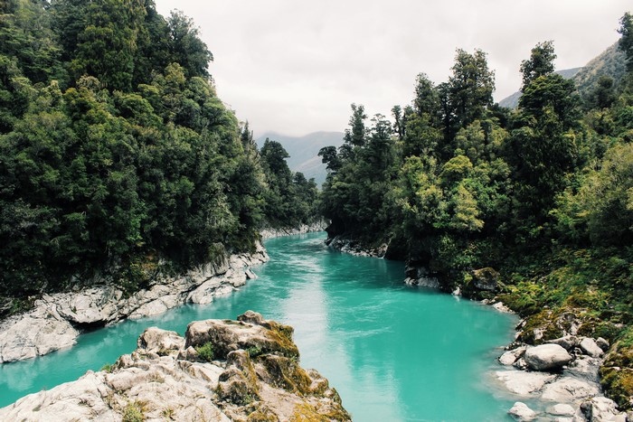 4K Turquoise River Through Forested Mountains