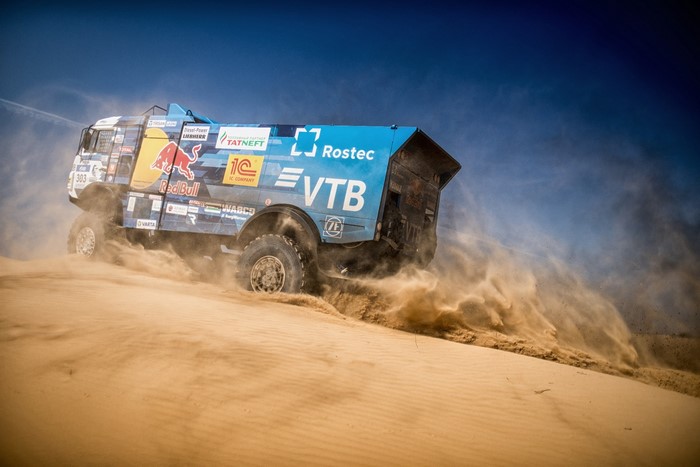 Kamaz truck racing through desert sand dunes