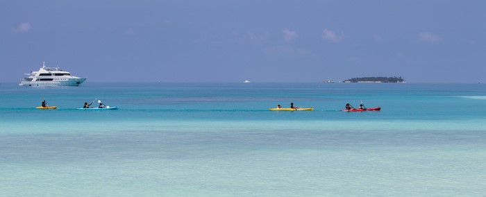Kayakers and a yacht in the Maldives