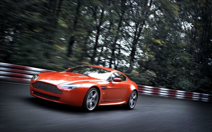 Orange Aston Martin Vantage driving on a race track