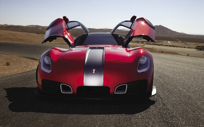 Red sports car with butterfly doors on a road
