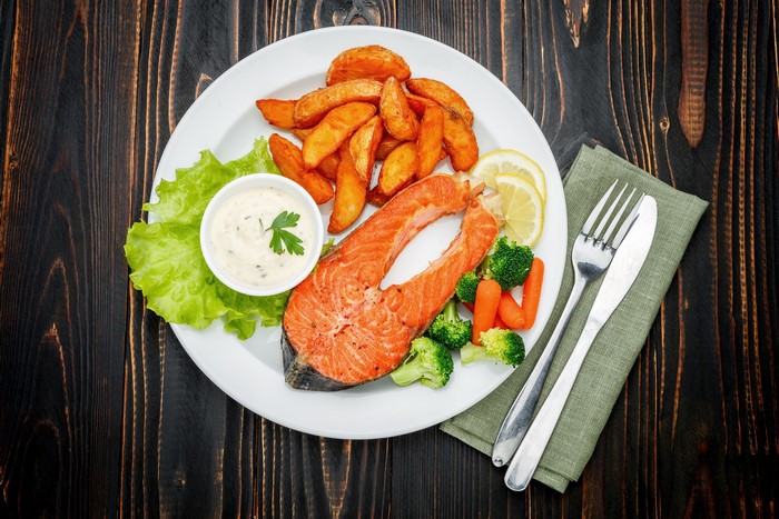 Salmon steak with roasted potatoes and vegetables