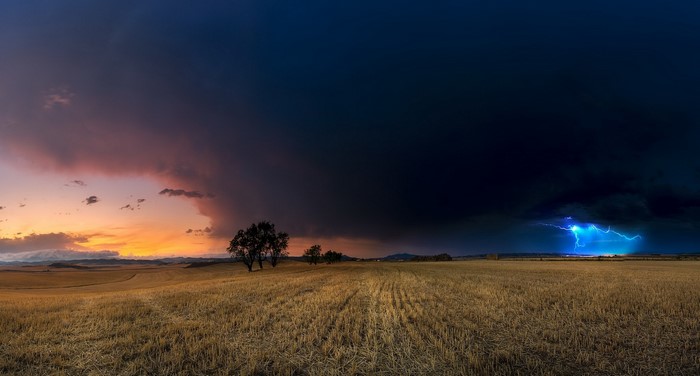 Stormy sky over a harvested field with lightning