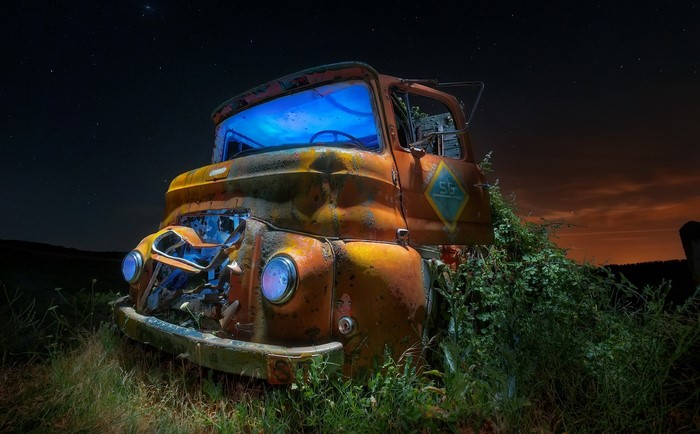 Abandoned rusty truck at night with stars