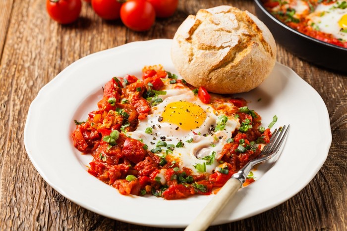 Shakshuka with Egg and Bread on Wooden Surface