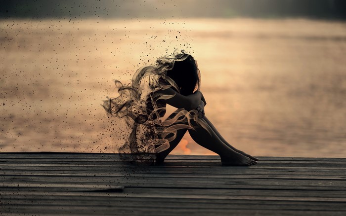 Woman dissolving into smoke and particles