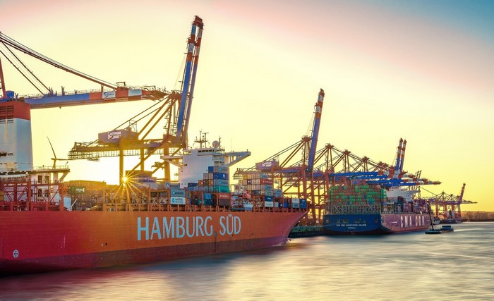 Container ships and cranes at Hamburg Sud port at sunset