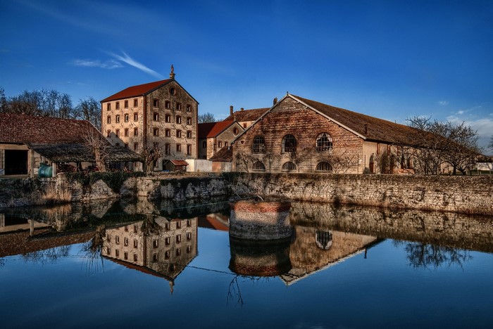 Old industrial buildings reflected in water in France
